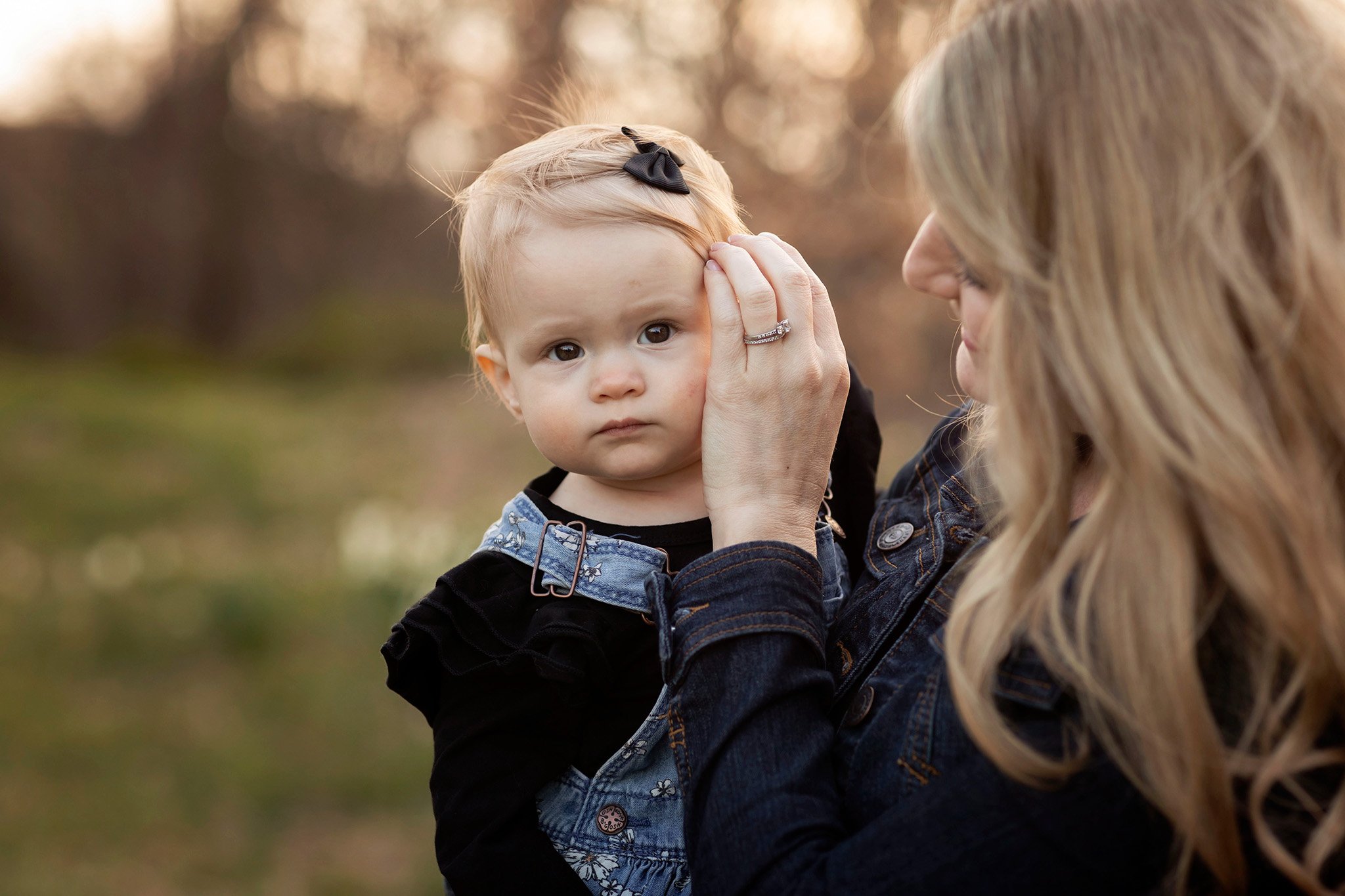 Family photography mom brushes little girl's hair
