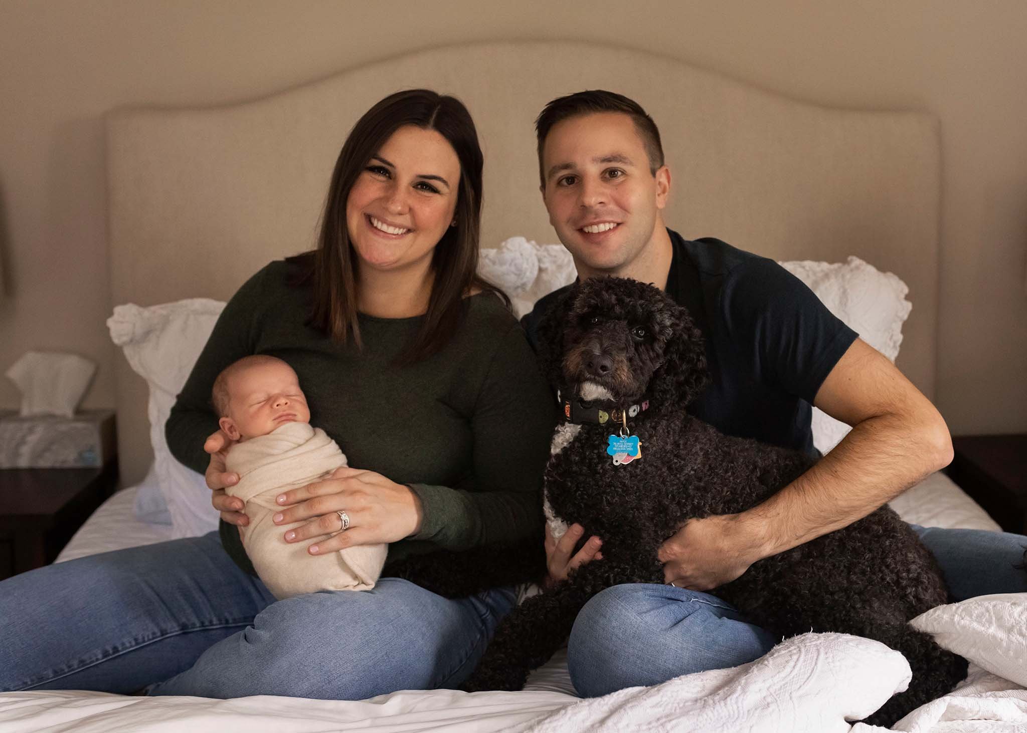 family on bed with baby and dog