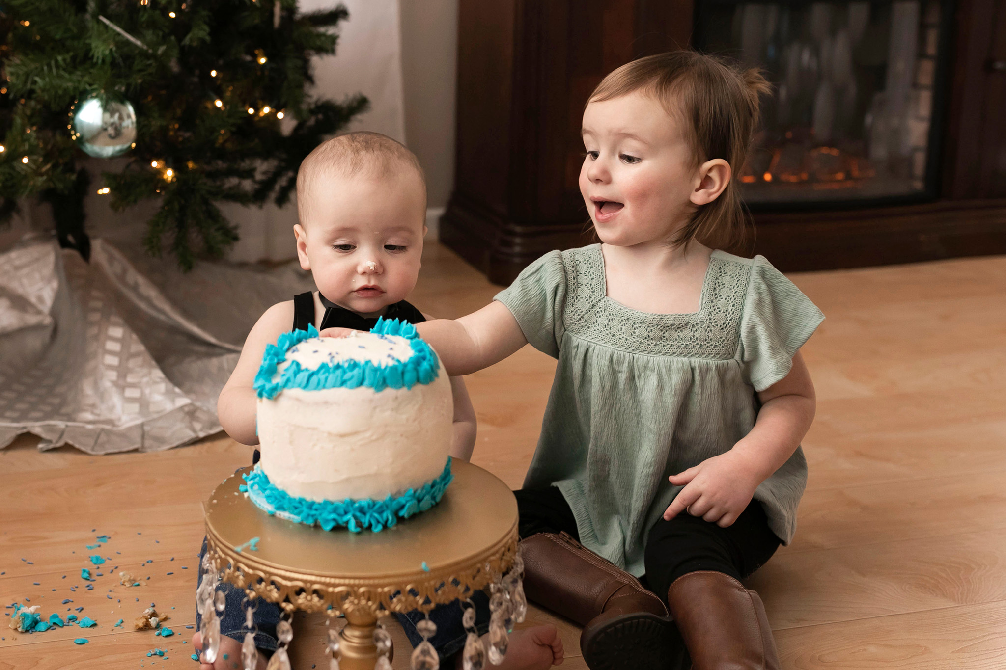 Big Sister tries to help her little brother with his cake