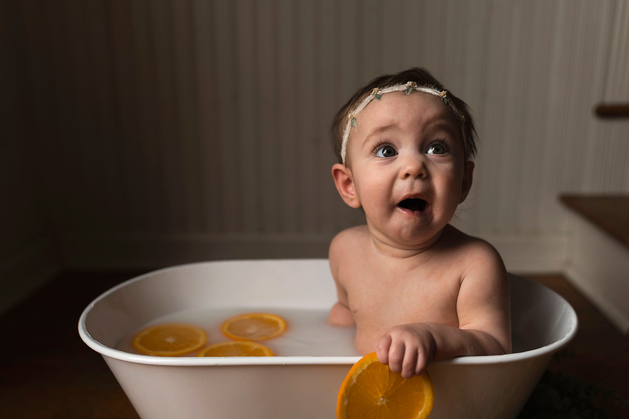 Baby holds orange during NJ Milk Bath Photography session