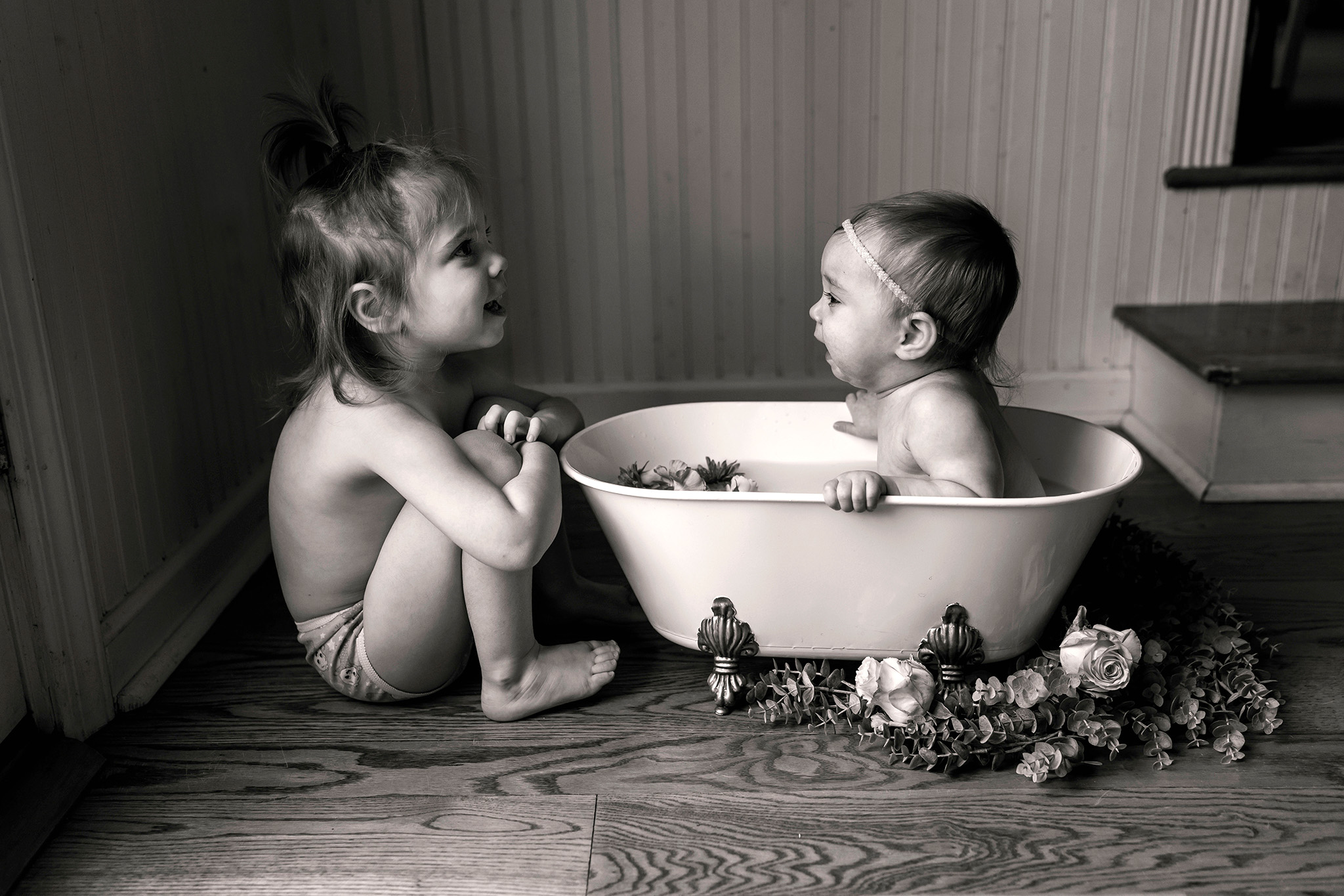 Baby plays with her big sister in her NJ milk bath photography session