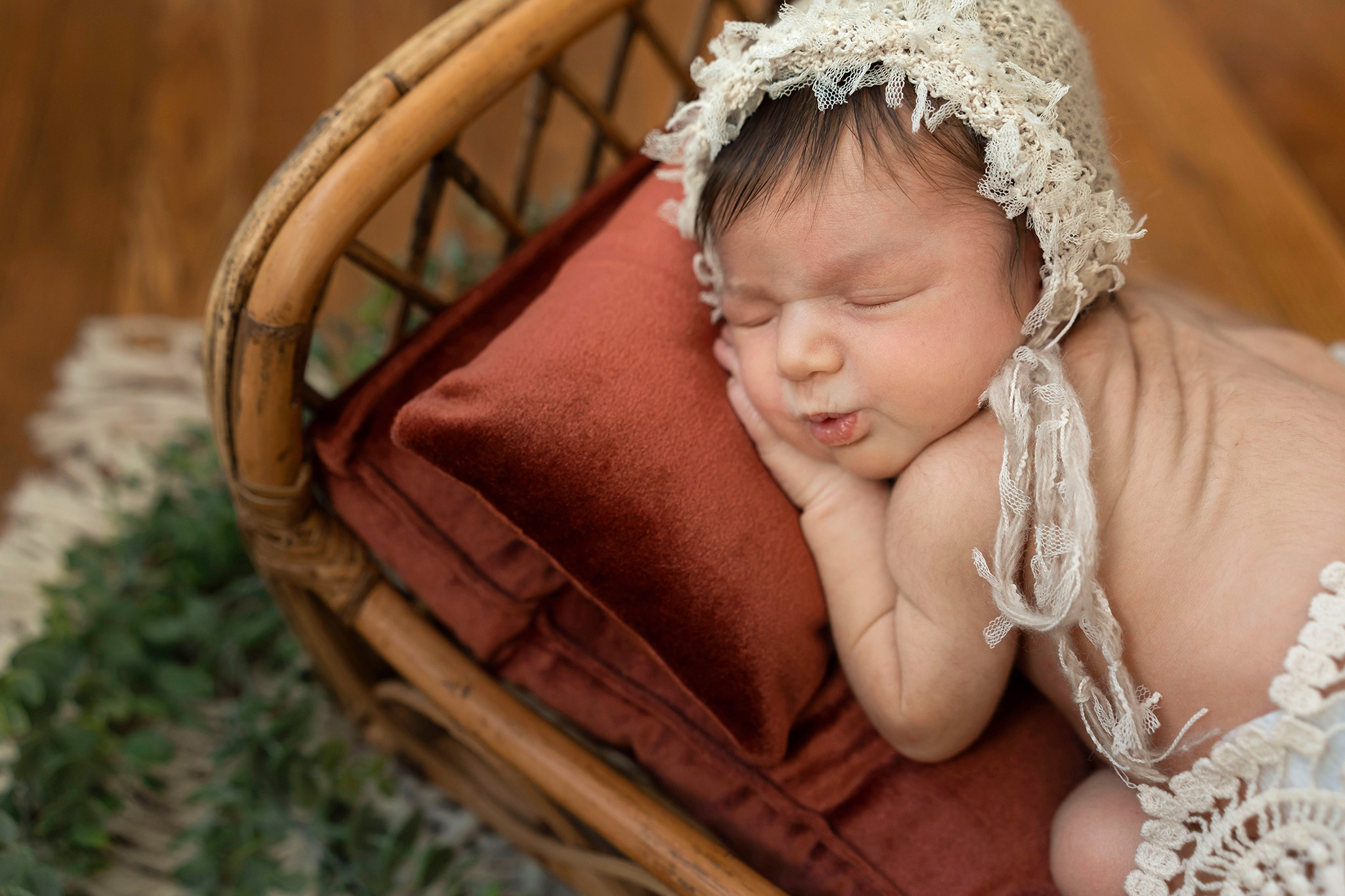 Baby wearing a bonnet while laying on a bamboo bed I New Jersey Newborn Photography