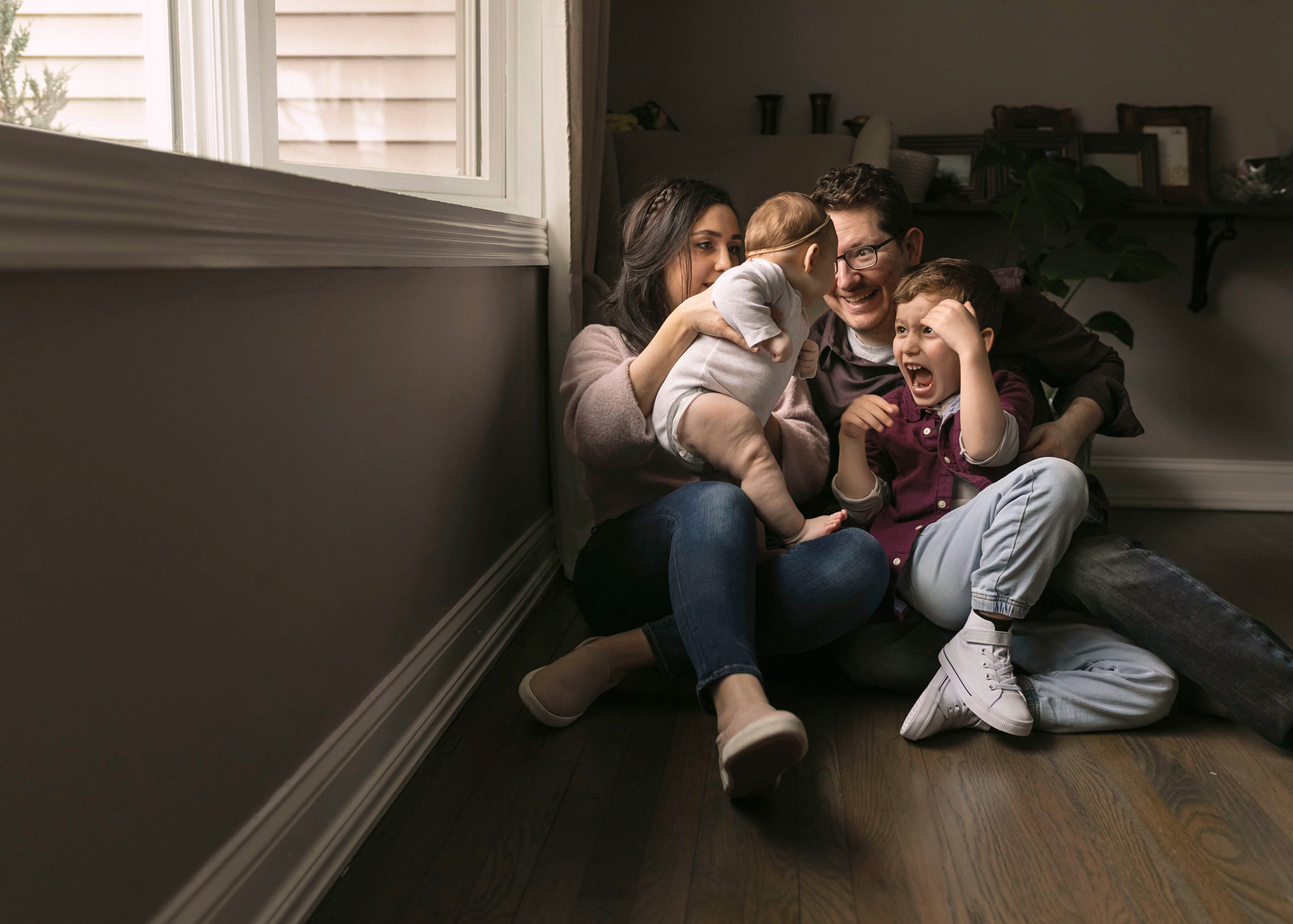 Family plays together on the floor of their living room I Whirlwind Cleaning NJ