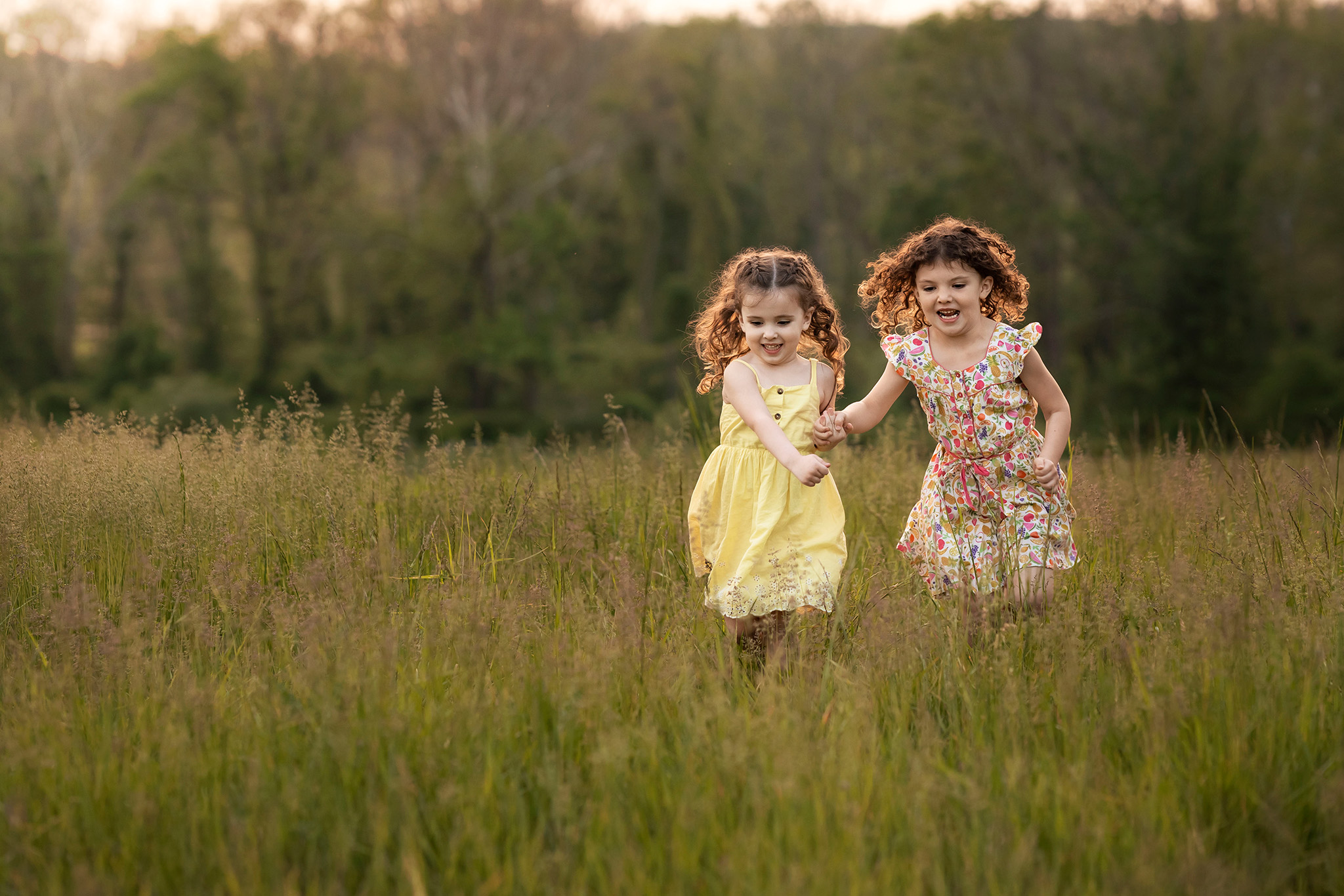 Two sisters running through a field