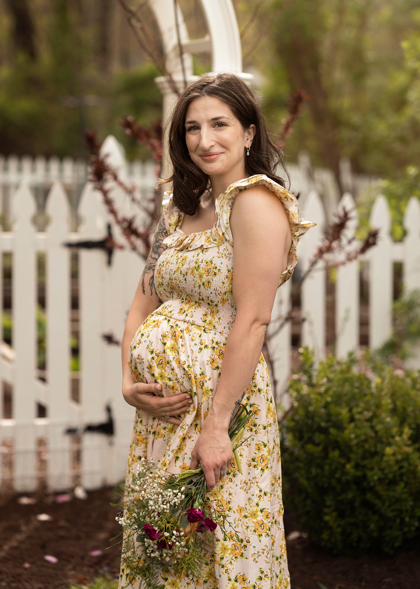 Pregnant mom holds her belly and flowers